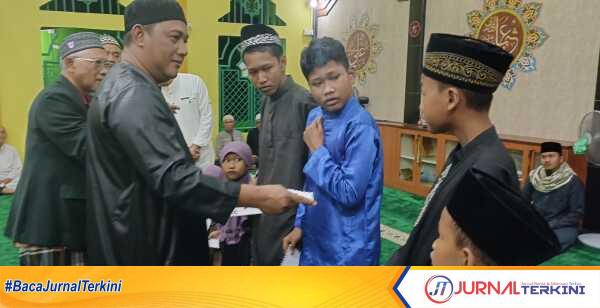 Abdul Razak, anggota DPRD Karimun menyerahkan santunan untuk anak yatim dan yatim piatu dalam acara peringatan Isra Miraj Nabi Muhammad SAW di Masjid Al Mujahidin, Kelurahan Harjosari, Kecamatan Tebing, Kabupaten Karimun, Kepulauan Riau, Rabu (29/1/2025) malam. (JurnalTerkini.id/edy kencana)