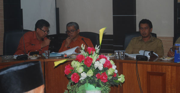 Kepala Dinas Penanaman Modal Perizinan Terpadu Satu Pintu (DPMPTSP) Karimun, Sularno (kanan), berdiskusi dengan staf di sela hearing bersama Komisi 3 DPRD Karimun, yang membahas reklamasi atau penimbunan pantai oleh PT Karimun Marine Shipyard (KMS).