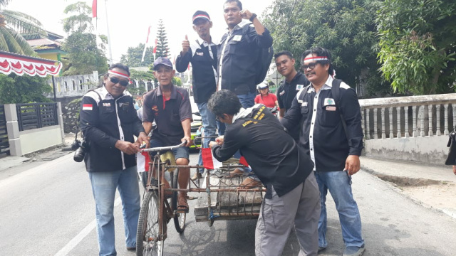 Ketua IWO Karimun bersama pengurus lainnya memasang bendera merah putih pada becak yang berhenti di simpang lampu merah Sei Lakam, Kamis (15/8). Foto: istimewa Ketua IWO Karimun bersama pengurus lainnya memasang bendera merah putih pada becak yang berhenti di simpang lampu merah Sei Lakam, Kamis (15/8). Foto: istimewa