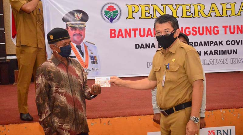 BLT Dana Desa Tanjunghutan 182 keluarga. Foto: Kepala Dinas Pemberdayaan Masyarakat Desa Karimun Suwedi secara simbolis menyerahkan BLT Dana Desa. (foto: Humas Pemkab Karimun)