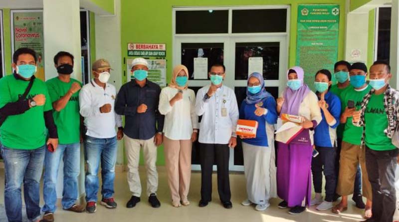 Anggota DPRD Karimun Charli Donna Sitorus (5 kiri) bersama relawan Kawan Donna berfoto bersama tim medis Puskesmas Kecamatan Karimun. Charli Donna sumbang vitamin untuk petugas medis, ODP, PDP dan pasien COVID-19. (foto: istimewa)