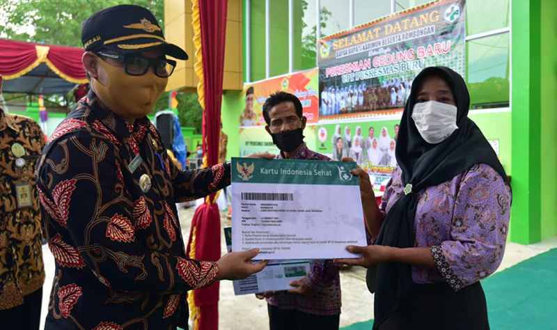 Camat Buru Helmi secara simbolis menyerahkan program Kartu Indonesia Sehat di sela peresmian gedung UPT Puskesmas Buru.