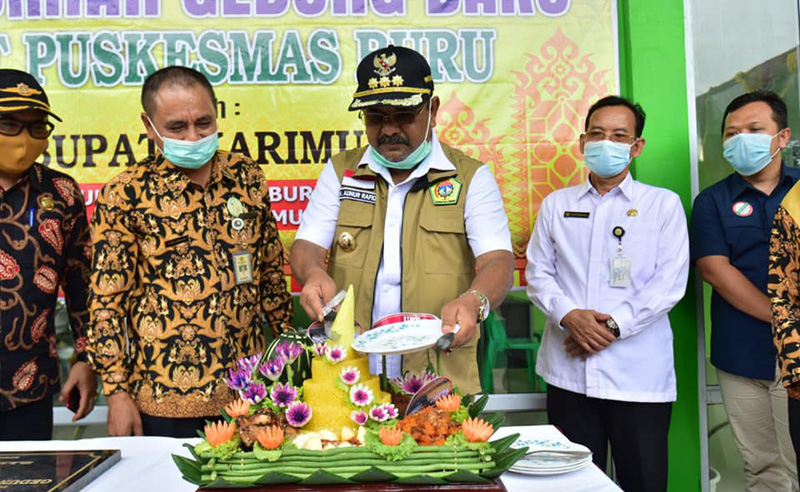 Bupati Karimun Aunur Rafiq memotong tumpeng tanda syukur dengan diresmikannya gedung baru UPT Puskesmas Buru.