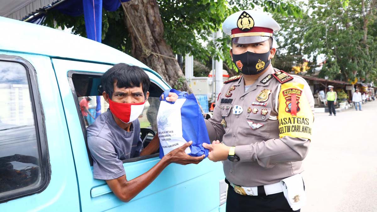 Kasat Lantas Polres Karimun AKP R Moch. Dwi Ramadhanto memberikan bingkisan kepada sopur oplet. (foto: yra)