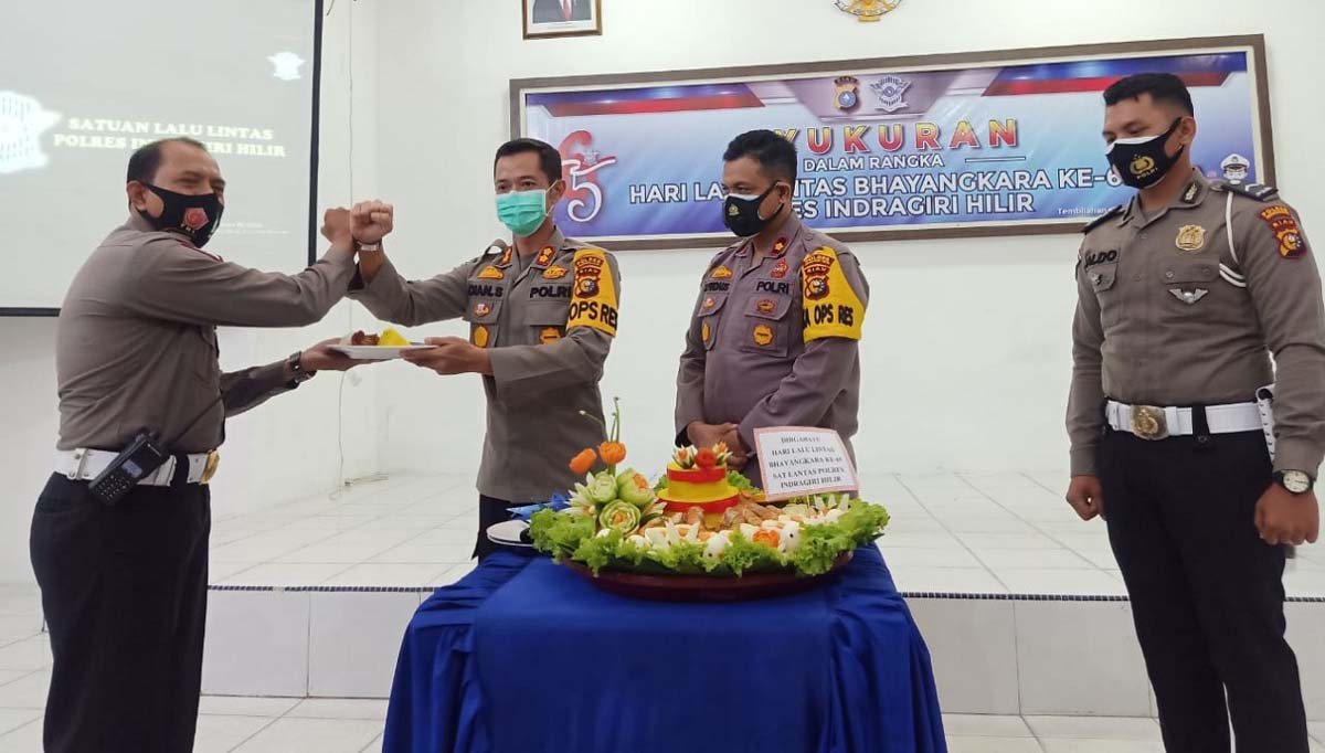Kapolres Inhil menyerahkan nasi tumpeng kepada Kasat Lantas. HUT Lalu Lintas ke-65, ini harapan Kapolres Inhil. (foto: abd)