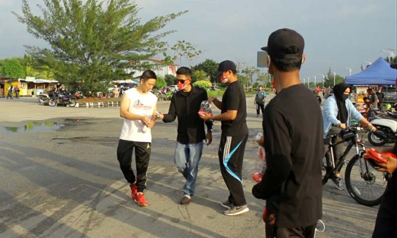 SIMAK-Karimun-bagi-bagi-masker Komunitas anak muda Soerya-Iman Milenial Karimun (SIMAK) membagikan masker kepada seorang pejalan kaki. Salut! Hari libur, Relawan Soerya-Iman Milenial Karimun bagi-bagi masker. (foto: istimewa)