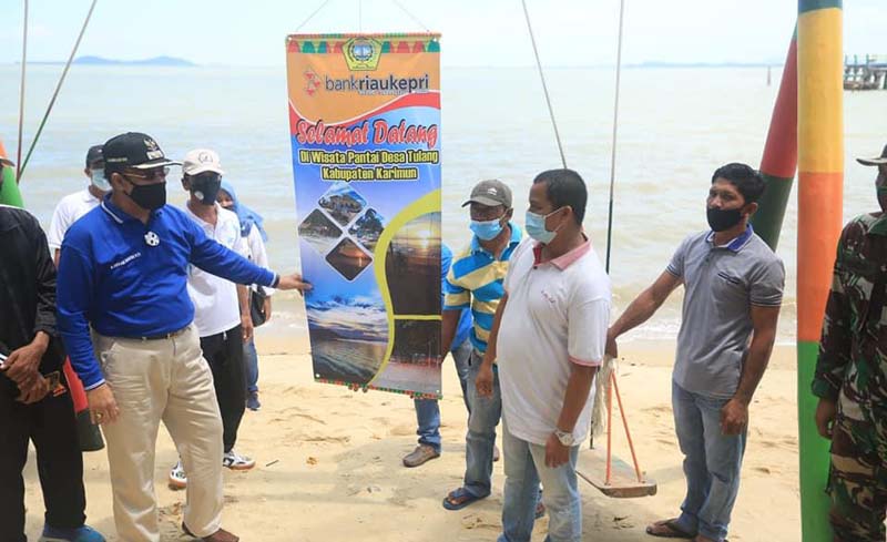 Kepala Cabang Bank Riaukepri Wan Abdurrahman (kanan) bersama Wakil Bupati Karimun Anwar Hasyim (kiri) ketika meresmikan fasilitas obyek wisata Pantai Tulang, Desa Tulang. Destinasi Pantai Tulang di Karimun makin layak dikunjungi, ini alasannya. (foto: Dok. Humas Pemkab Karimun)