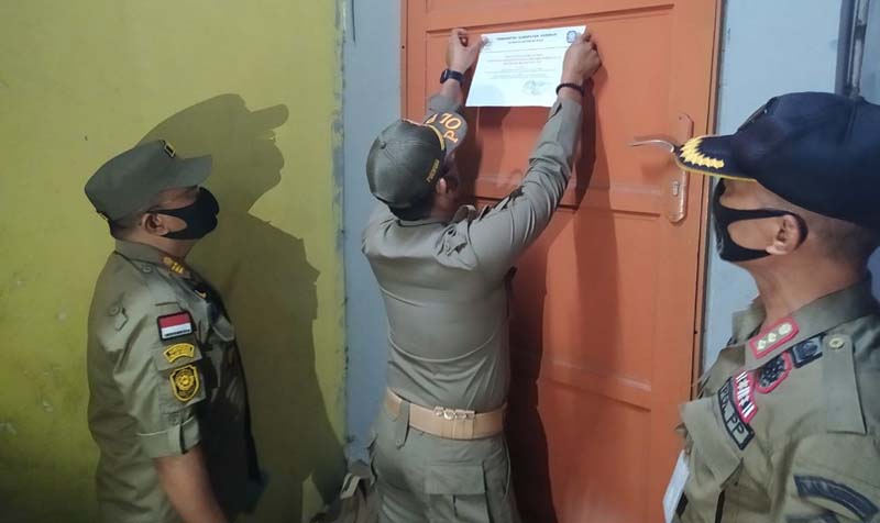 Satpol PP Karimun memasang surat peringatan di salah satu lokasi gelper. (foto: yra)
