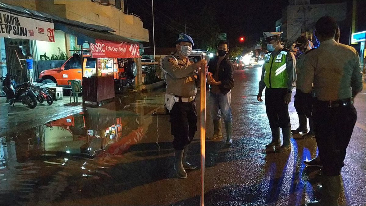 Personel Polres Inhil menyedot genangan air di Jl M Boya untuk mencegah banjir. (Foto: abd)