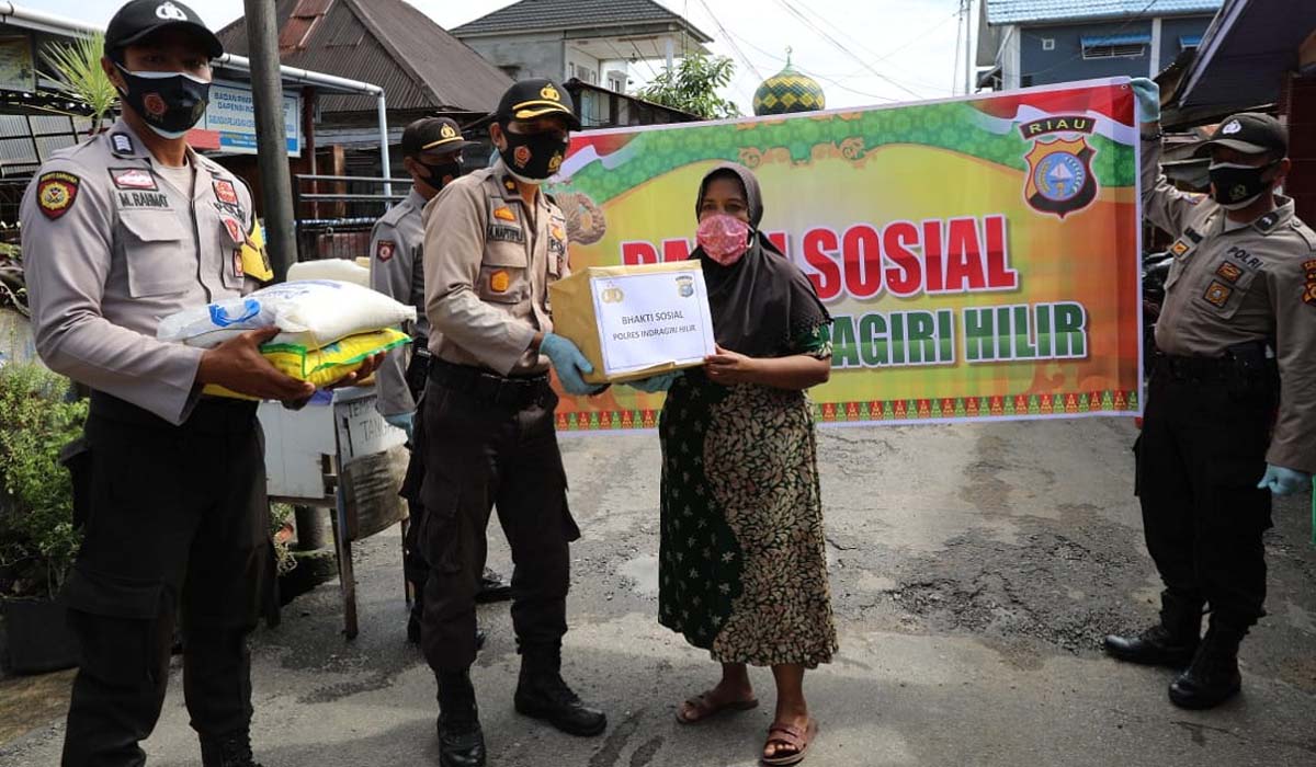 Polres Inhil bantu sembako covid-19 Wakapolres Inhil menyerahkan bantuan paket sembako kepada warga. Polres Inhil bagi-bagi sembako di Kampung Jawa Tembilahan. (foto: abd)
