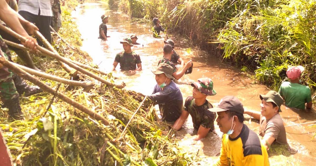 Ketua DPRD Inhil DR Ferryandi terjun ke parit bersama warga membersihkan sampah. (foto: abd)