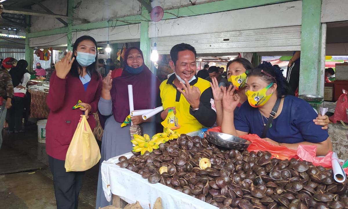 Ketua Tim Pemenangan AMAN Wiyono dan tim relawan berpose saat membagikan masker di Pasar Puan Maimun, Sabtu (28/11/2020) sore. (foto: yra)
