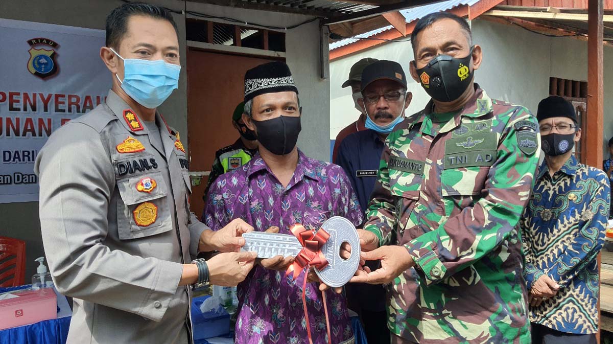 Bedah rumah polres inhil-1 Kapolres Inhil AKBP Dian Setyawan dan Kasdim 0314/Inhil Letkol (inf) Untung Kusmanto secara simbolis menyerahkan kunci rumah kepada salah satu korban kebakaran. (foto: abd)
