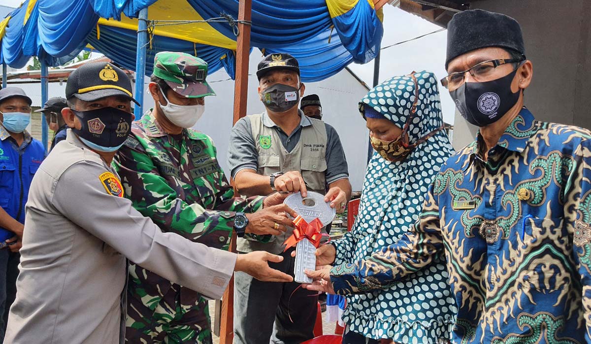 Korban kebakaran menerima kunci rumah yang telah direhabilitasi. (foto: abd)