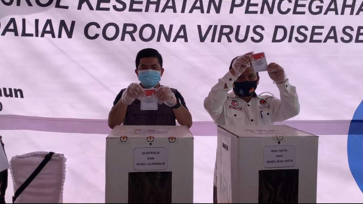 Ketua KPU Karimun Eko Purwandoko dan komisioner KPU Martinus mencontohkan pemungutan suara dalam simulasi Pilkada Serentak 2020 di Kelurahan Harjosari, Kecamatan Tebing, Sabtu (22/11/2020). (Foto: yra)