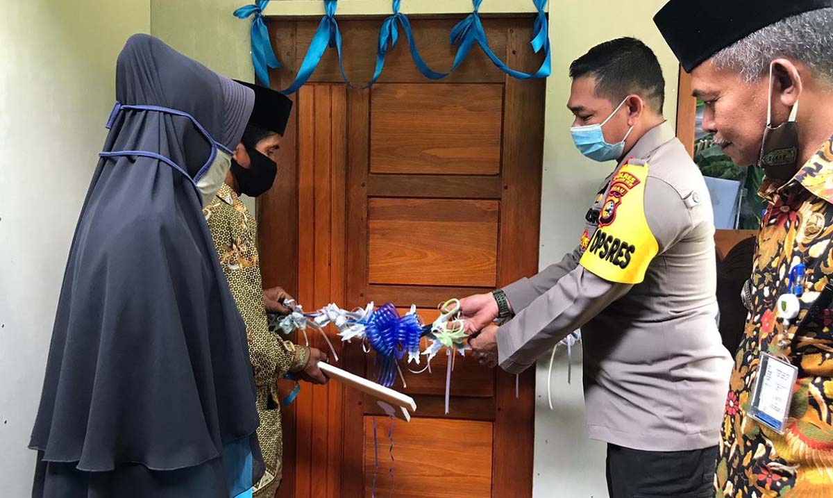 Wakapolres Inhil Kompol Kari Amsah Ritonga menyerahkan kunci rumah Yusuf yang telah selesai direhabilitasi atau dibedah. (foto: abd)