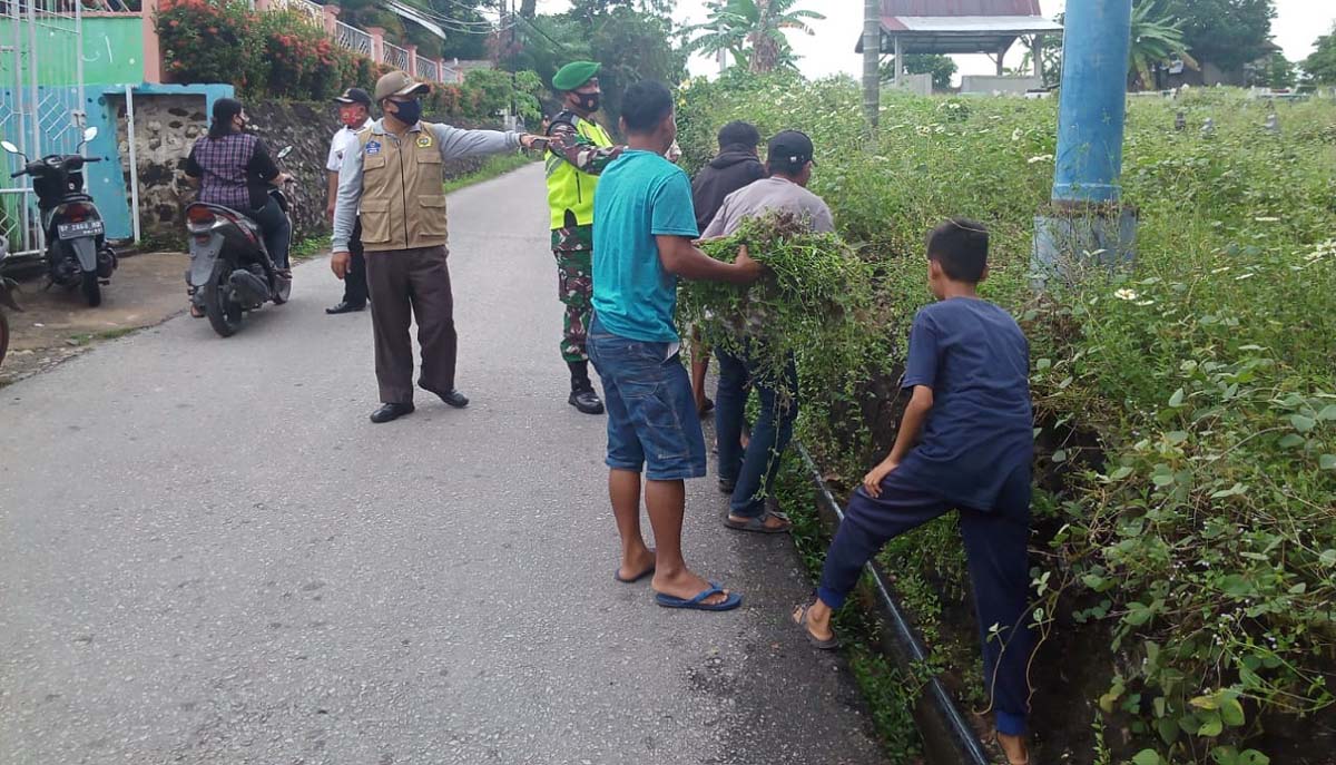 Razia masker di Kecamatan Moro Karimun Camat Moro Khaidir mengawasi warganya yang dihukum membersihkan jalan karena tidak menggunakan masker, Rabu (4/11/2020). (foto: istimewa)