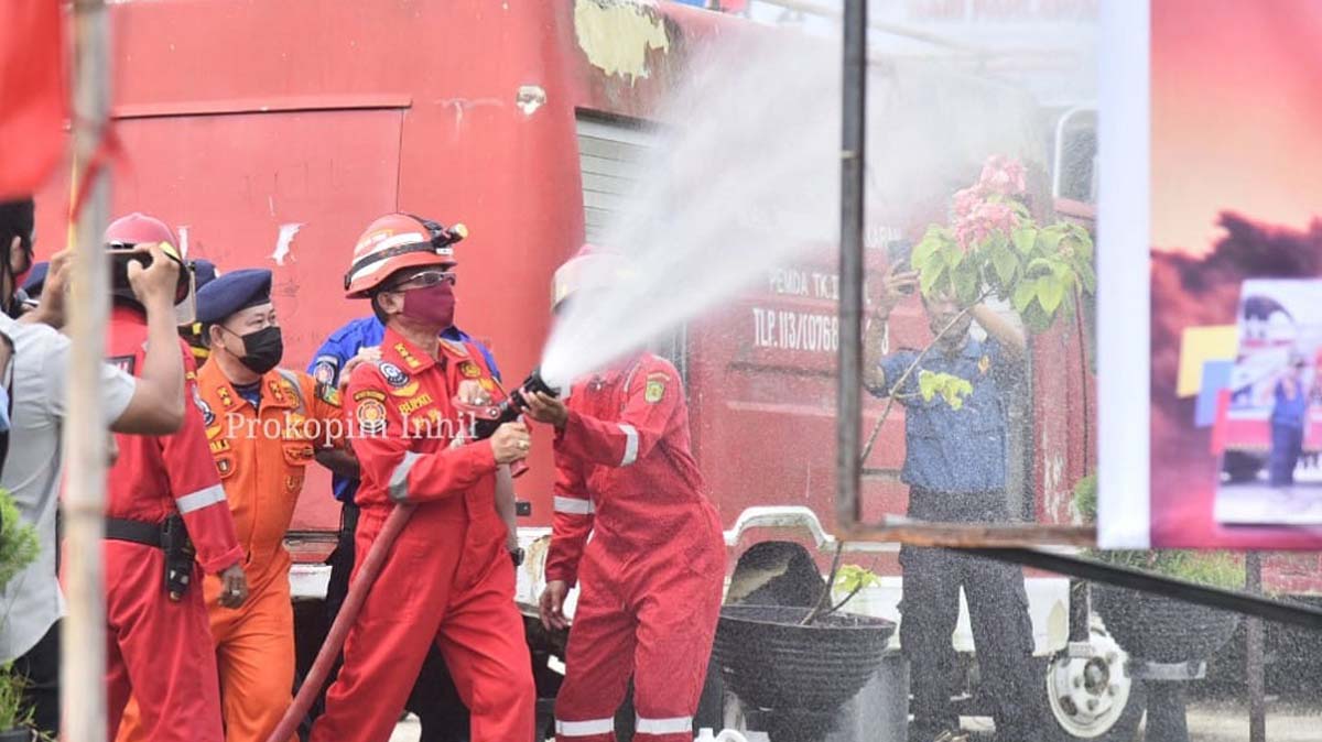 Petugas Damkar melakukan simulasi pemadam kebakaran di sela apel yang dipimpin Bupati Inhil HM Wardan. (foto: Prokopim Pemkab Inhil)