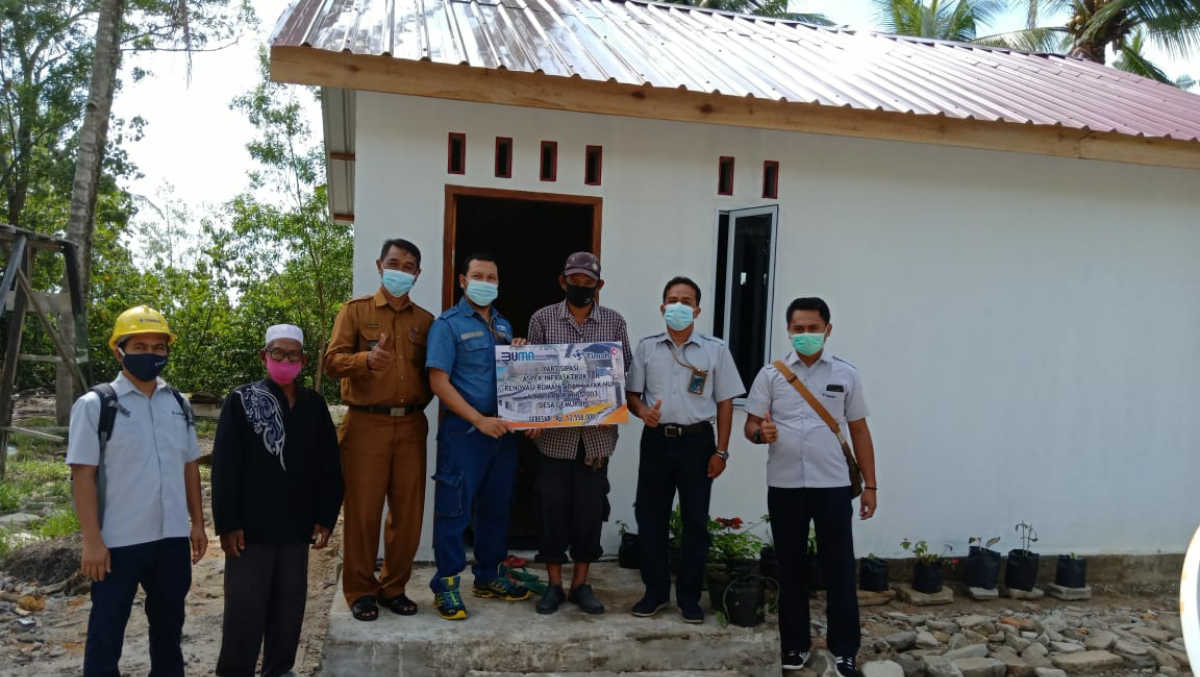 Warga Desa Gemuruh, Kundur Barat, Azlan berfoto bersama manajemen PT Timah Wilayah Operasi Kepri dan Riau di depan rumahnya yang selesai direnovasi. (foto: istimewa)