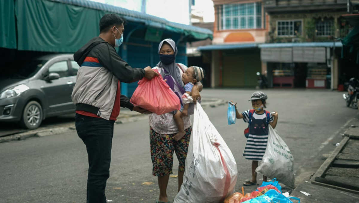 Koordinator Razia Perut Lapar Jerrico Danish memberikan nasi kotak kepada salah seorang pemulung di Tanjung Balai Karimun. (foto: yogi)
