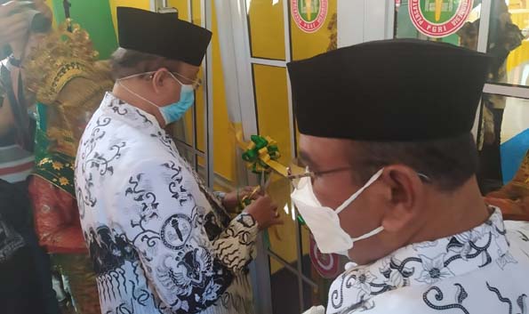 Wakil Bupati Karimun Anwar Hasyim membuka kunci pintu gedung PGRI Karimun yang diresmikan pemakaiannya, Senin (14/12/2020). (foto: yra)