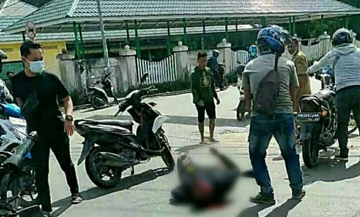 kecelakaan di tembilahan Salah satu korban tergeletak di jalan usai tabrakan. (foto: abd)