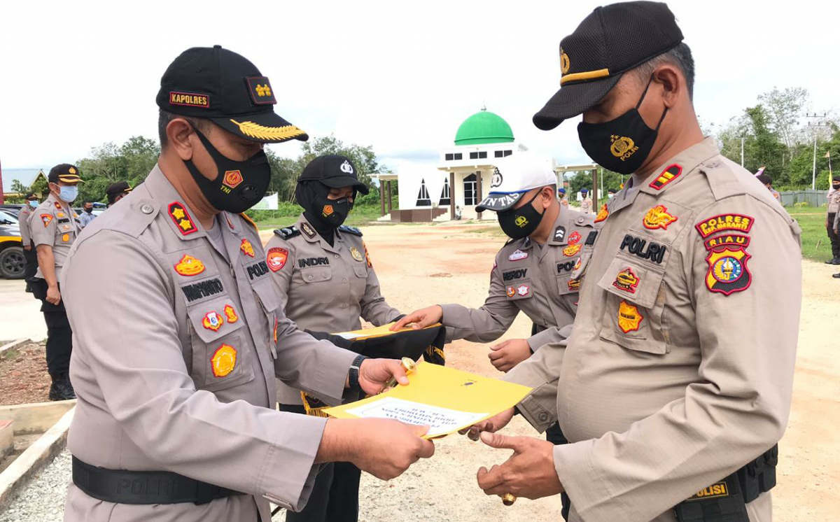 Kapolres Meranti memberikan penghargaan kepada personel berprestasi dalam penanganan COVID-19.
