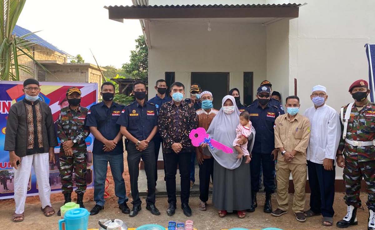 Kajari Karimun Rahmat dan pengurus DPC Patron Karimun befoto bersama penerima program bedah rumah. (foto: yra)