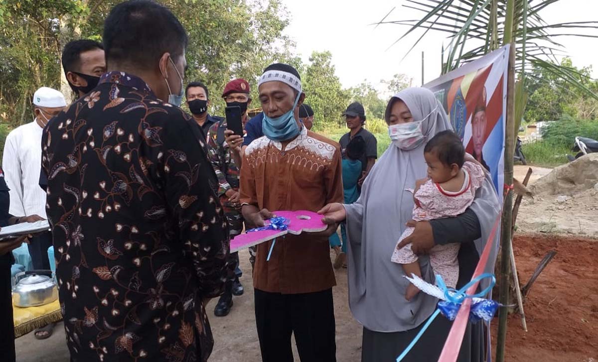 Kajari Karimun Rahmat Azhar menyerahkan kunci rumah kepada Galih, penerima program bedah rumah, Jumat (29/1/2021). (foto: yra)