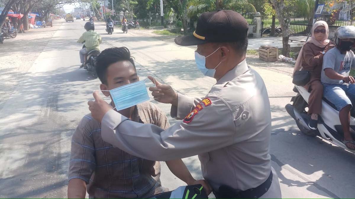 Program 100 Hari Kapolri, Polres Inhil bagi masker dan memberikan imbauan prokes kepada masyarakat. (foto: abdullah)