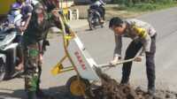 TNI-Polri gotong royong Tentara dan polisi goro tambal jalan berlubang di Musi Rawas, Minggu (28/2/2021)
