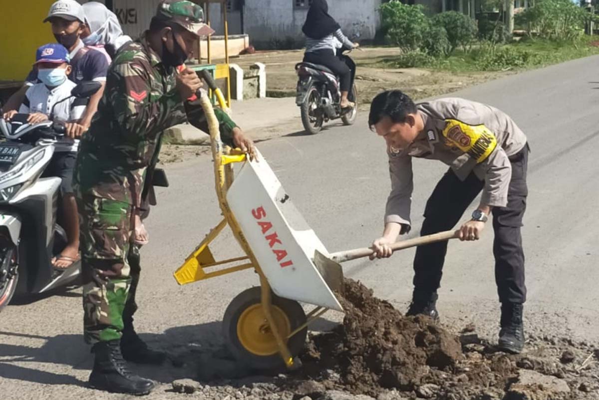 TNI-Polri gotong royong Tentara dan polisi goro tambal jalan berlubang di Musi Rawas, Minggu (28/2/2021)