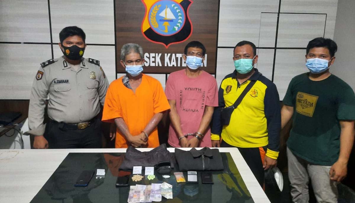 Lagi transaksi sabu dan ekstasi, dua pria di Kateman diciduk polisi. Kedua tersanka (diborgol) setelah diamankan Polsek Kateman.