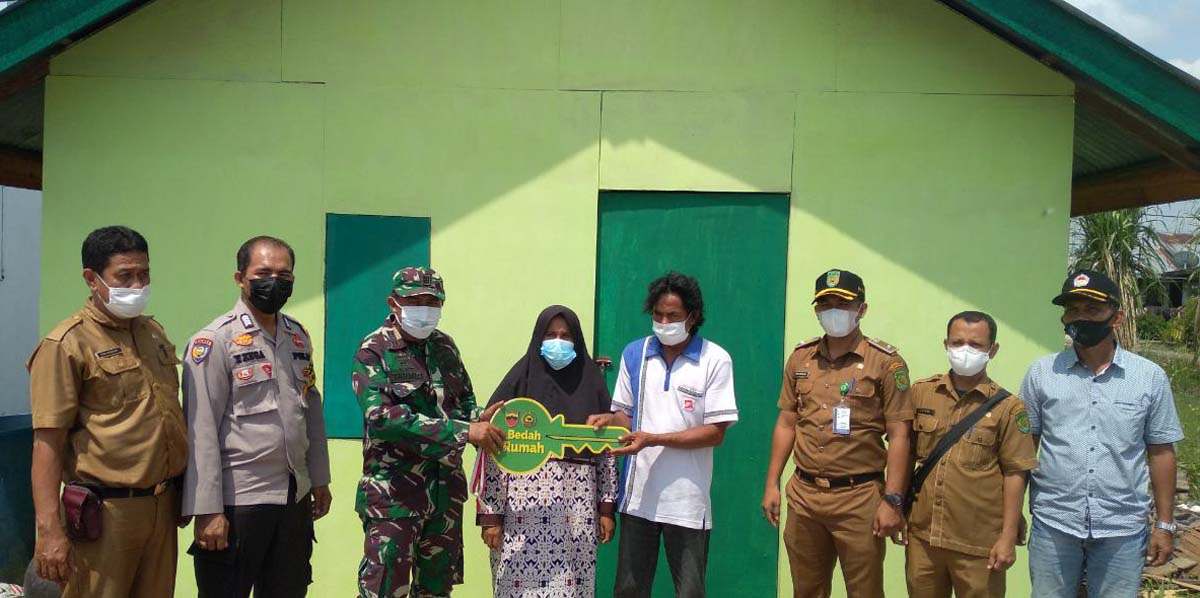 Penyerahan kunci rumah kepada Amin, warga yan rumahnya dibedah setelah rusak akibat angin kencang Jumat pekan lalu. (foto: abdullah)