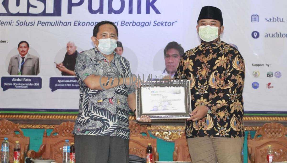 Abdul Fata Kepala Diskop dan UMKM saat menerima piagam penghargaan dari pengurus KSEI JEBIS IAIN Madura