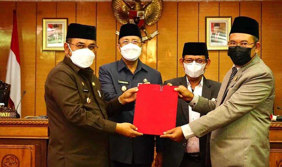 Bupati Karimun Aunur Rafiq didampingi Wakil Bupati Anwar Hasyim menyerahkan Raperda Pertanggungjawaban Pelaksanaan APBD 2020 yang disahkan menjadi Perda kepada Ketua DPRD M Yusuf Sirat didampingi Wakil Ketua Rasno. (foto: Humas Pemkab Karimun)