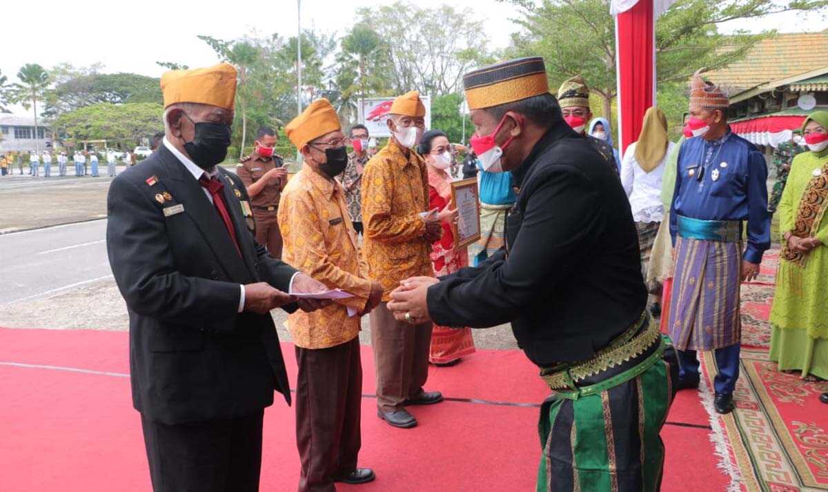 Wakil Ketua III DPRD Inhil Andi Rusli menyerahkan bingkisan kepada veteran.