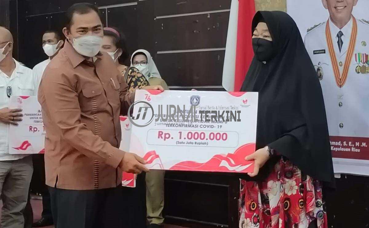 Anggota DPRD Kepri Bakti Lubis menyerahkan bantuan sosial dari Pemprov Kepri untuk warga tidak mampu terkonfirmasi positif COVID-19 di Gedung Nasional Tanjung Balai Karimun, Selasa (10/8/2021). (foto: yra)