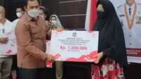 Anggota DPRD Kepri Bakti Lubis menyerahkan bantuan sosial dari Pemprov Kepri untuk warga tidak mampu terkonfirmasi positif COVID-19 di Gedung Nasional Tanjung Balai Karimun, Selasa (10/8/2021). (foto: yra)
