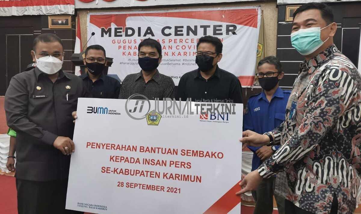 Kepala BNI Cabang Karimun Risnaldi (kanan) secara simbolis menyerahkan bansos berupa sembako kepada Bupati Karimun Aunur Rafiq untuk insan pers di Gedung Nasional, Tanjung Balai Karimun, Selasa (28/9/2021). (foto: yra)