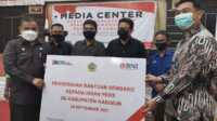 Kepala BNI Cabang Karimun Risnaldi (kanan) secara simbolis menyerahkan bansos berupa sembako kepada Bupati Karimun Aunur Rafiq untuk insan pers di Gedung Nasional, Tanjung Balai Karimun, Selasa (28/9/2021). (foto: yra)