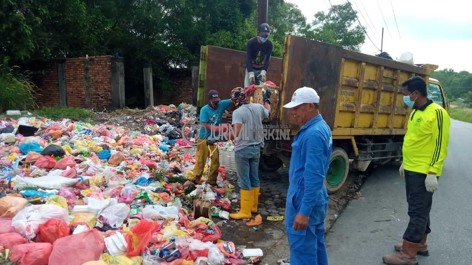 Petugas DLH Karimun mengangkat sampah yang menumpuk di salah satu ruas jalan di Tanjung Balai Karimun. (foto: yra)