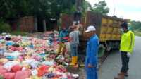 Petugas DLH Karimun mengangkat sampah yang menumpuk di salah satu ruas jalan di Tanjung Balai Karimun. (foto: yra)