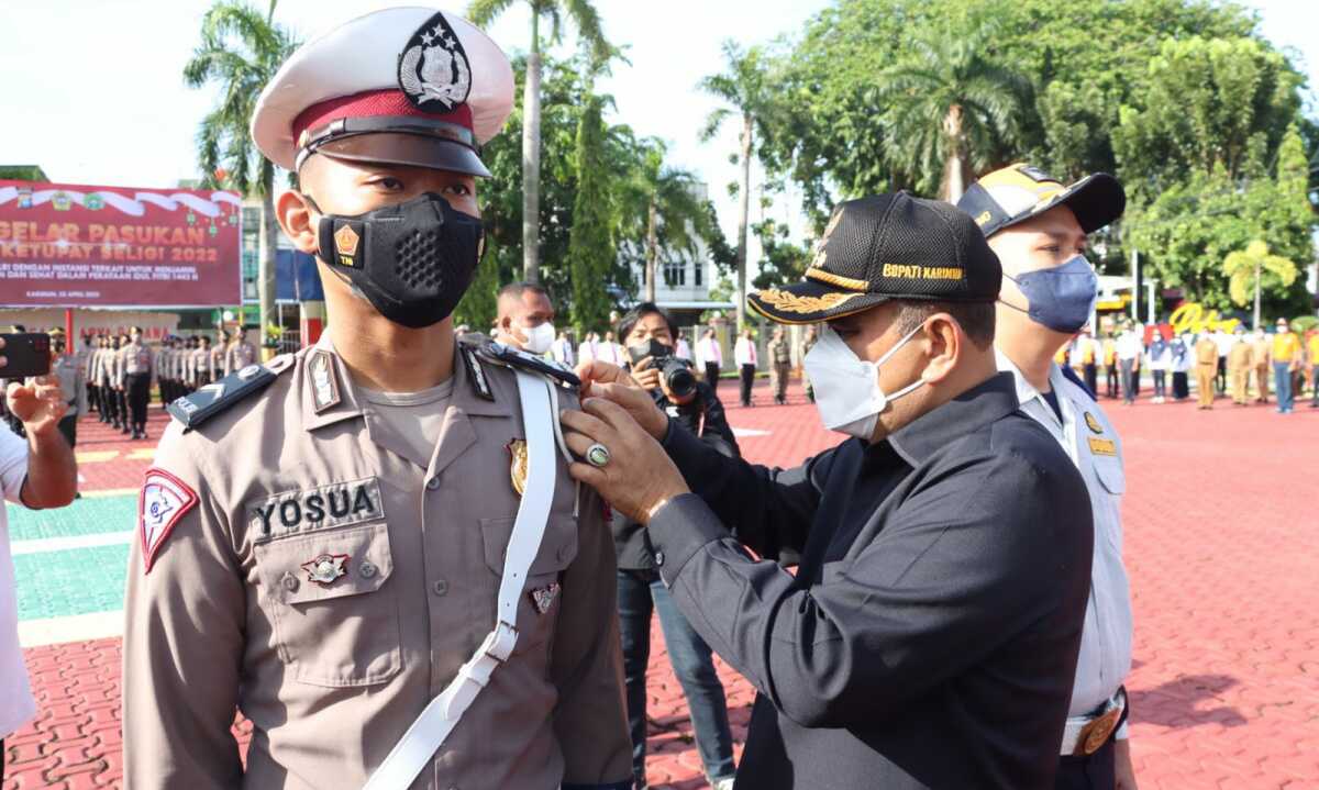 Bupati Karimun Aunur Rafiq menyematkan pita kepada personel yang terlibat dalam Operasi Ketupat Seligi 2022. (foto: Dok. Humas Polres Karimun)