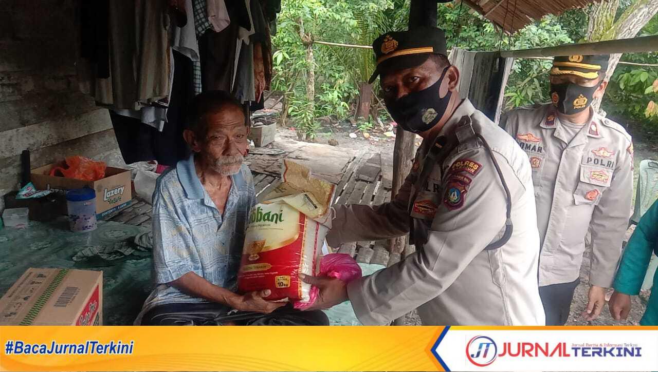 Kapolsek Kundur, Kompol Muhamad Komarudin memberikan sembako kepada seorang warga kurang mampu. (Jurnal/Ist)