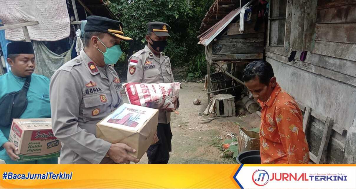 Kapolsek Kundur, Kompol Muhamad Komarudin memberikan sembako kepada salah seorang warg kurang mampu. (Jurnal/Ist)