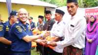 Kepala KSOP Kelas I Tanjungbalai Karimun, Jon Kenedi menyerahkan e-pas kecil kepada salah seorang nelayan di Desa Tulang