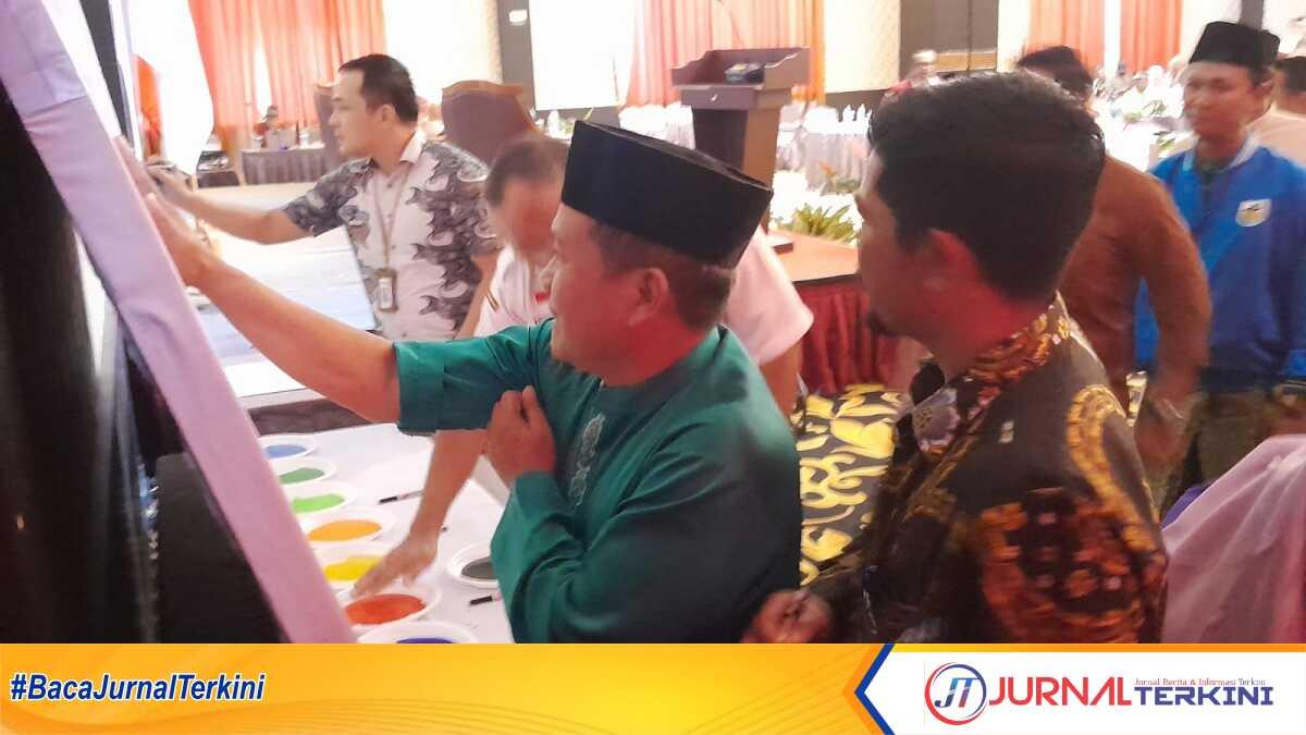 deklarasi pemilu berintegritas bawaslu karimun Ketua Bawaslu Karimun Nurhidayat (kanan) dan Ketua KPU Karimun Eko Purwandoko membubuhkan cap telapak tangan pada selembar kain putih wujud komitmen mendorong terlaksananya Pemilu 2024 di sela acara sosialisasi perarutan Pemilu 2024 yang digelar Bawaslu Karimun di Ballrom Hotel Aston Karimun Citiy, Rabu (21/9/2022). (foto: jurnalterkini.id/rusdi)