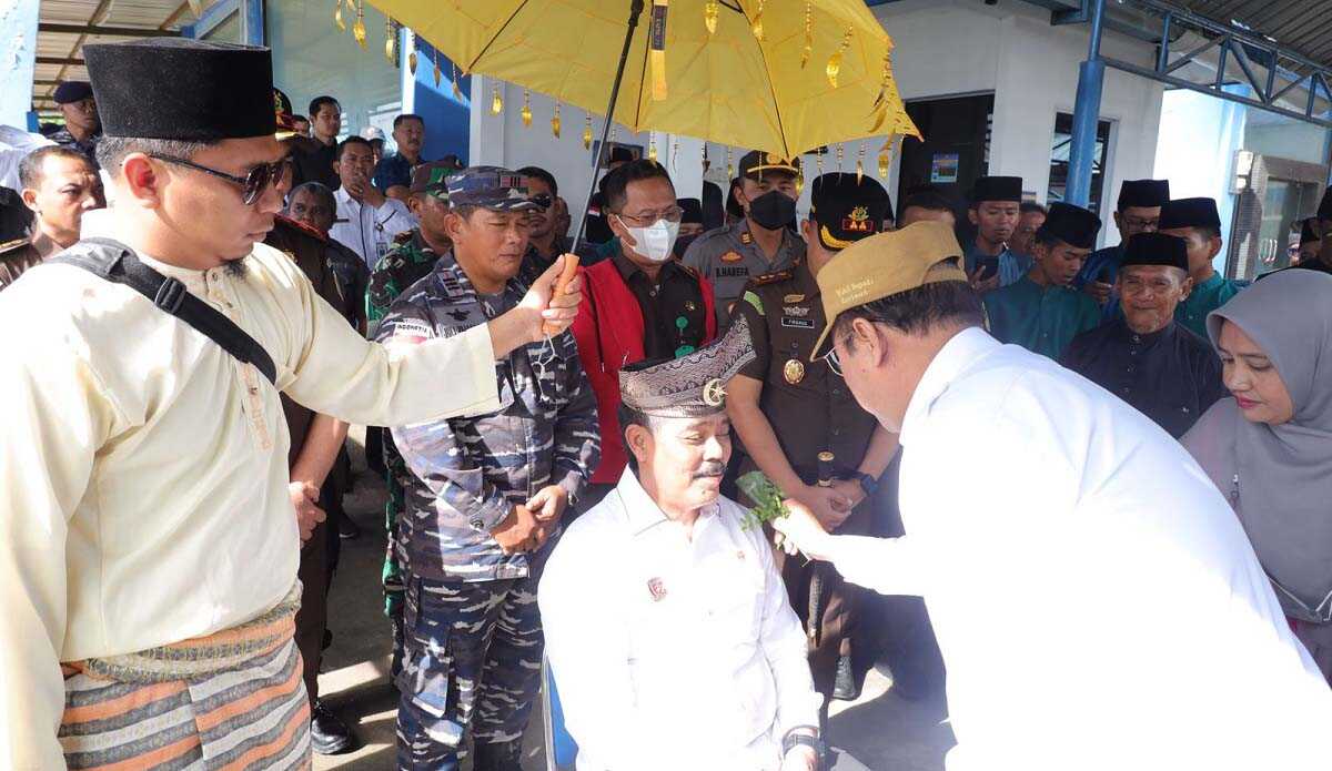 Wakil Bupati Karimun Anwar Hasyim memasangkan tanjak di kepala Kajati Kepri Gerry Yasid dalam kunjungannya ke Islamic Center di Kecamatan Kundur, Rabu (9/11/2022). (foto: Dok. Diskominfo Karimun)
