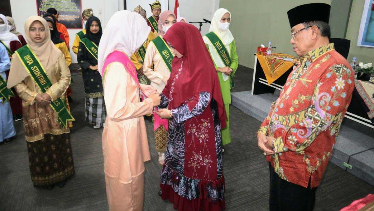 Ketua TP PKK Kabupaten Indragiri Hilir (Inhil) Hj Zulaikhah Wardan mengalungkan selendang Duta Stunting Inhil. (foto: Dok. Dinkes Inhil).